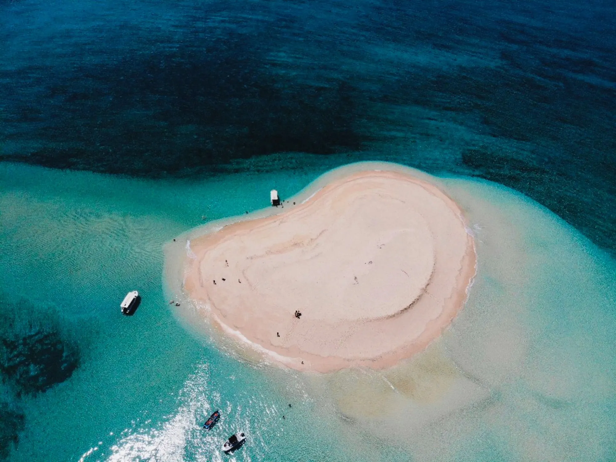 L’îlot de sable blanc vu du ciel, cerné d’eaux turquoise
