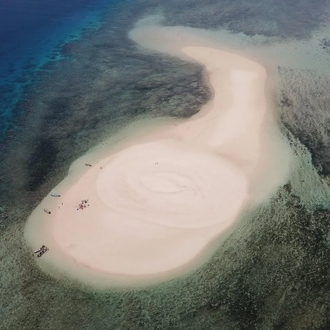 Le banc de sable en spirale vu du ciel, cerné par le récif et les eaux profondes